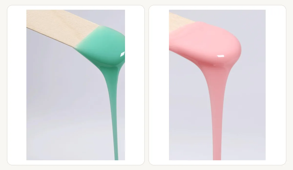 Two colourways of molten hard wax flowing off wooden applicators in a slow ribbon